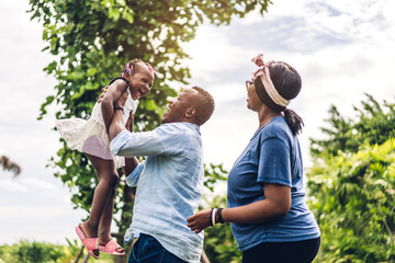 Portrait of enjoy happy love black family african american father and mother with little african girl child smiling and having fun moments good time in summer park at home