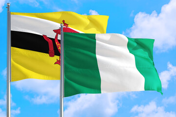 Nigeria and Brunei national flag waving in the windy deep blue sky. Diplomacy and international relations concept.