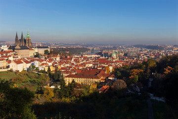 Obraz premium Autumn Prague City with gothic Castle and colorful Nature and Trees from the Hill Petrin, Czech Republic