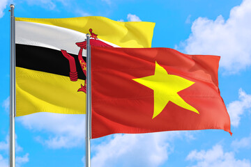 Vietnam and Brunei national flag waving in the windy deep blue sky. Diplomacy and international relations concept.