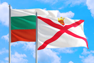 Jersey and Bulgaria national flag waving in the windy deep blue sky. Diplomacy and international relations concept.