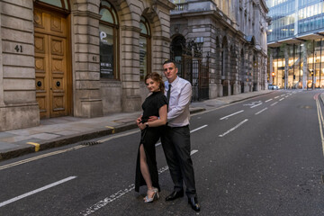 Young flirty couple posing on a street of City in London, UK