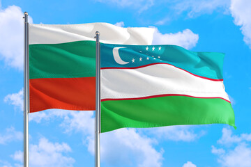 Fototapeta na wymiar Uzbekistan and Bulgaria national flag waving in the windy deep blue sky. Diplomacy and international relations concept.