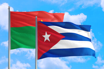 Cuba and Burkina Faso national flag waving in the windy deep blue sky. Diplomacy and international relations concept.