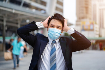 stressed business man with medical mask during coronavirus (covid-19) pandemic in city
