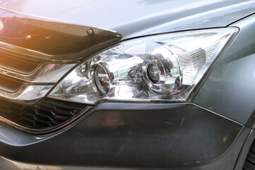 Big headlight cleaning on the car with power buffer machine at service station,Before and after cleaning car concept with a mechanic cleaning the headlights of a car using a power buffer machine