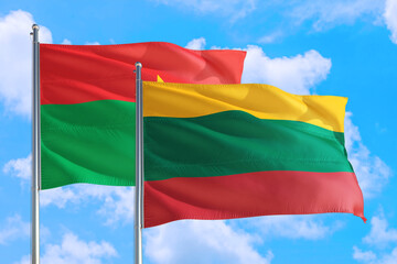 Lithuania and Burkina Faso national flag waving in the windy deep blue sky. Diplomacy and international relations concept.