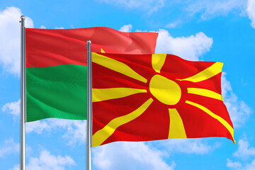Macedonia and Burkina Faso national flag waving in the windy deep blue sky. Diplomacy and international relations concept.