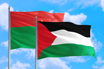 Palestine and Burkina Faso national flag waving in the windy deep blue sky. Diplomacy and international relations concept.
