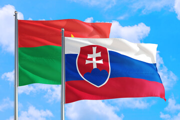 Slovakia and Burkina Faso national flag waving in the windy deep blue sky. Diplomacy and international relations concept.