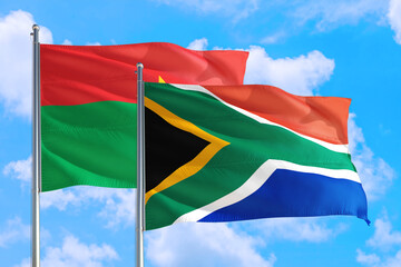 South Africa and Burkina Faso national flag waving in the windy deep blue sky. Diplomacy and international relations concept.