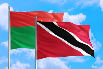 Trinidad And Tobago and Burkina Faso national flag waving in the windy deep blue sky. Diplomacy and international relations concept.