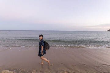 Young female walking at a white sand beach