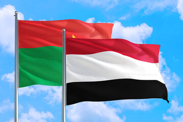 Yemen and Burkina Faso national flag waving in the windy deep blue sky. Diplomacy and international relations concept.