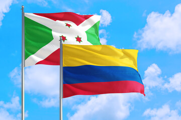 Colombia and Burundi national flag waving in the windy deep blue sky. Diplomacy and international relations concept.