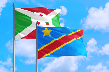 Congo and Burundi national flag waving in the windy deep blue sky. Diplomacy and international relations concept.