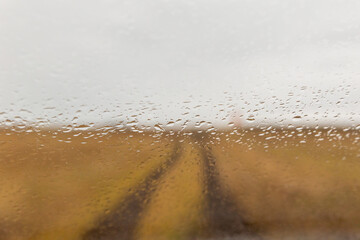 Closeup focus shot of windshield with water droplets on it in Icelandic landscape