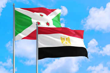 Egypt and Burundi national flag waving in the windy deep blue sky. Diplomacy and international relations concept.