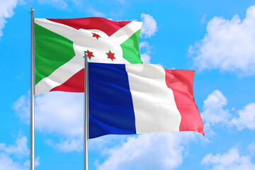 France and Burundi national flag waving in the windy deep blue sky. Diplomacy and international relations concept.