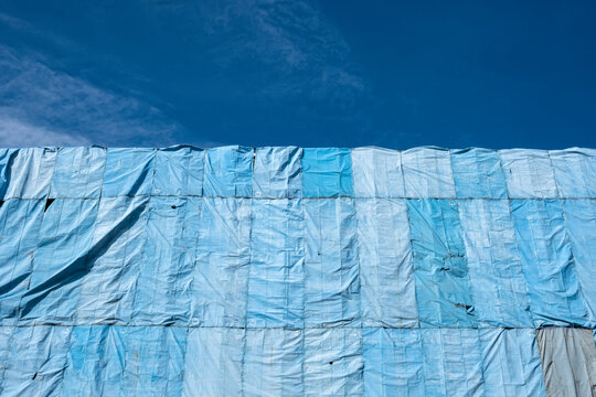 Abstract Detail Of Blue Tarpaulins With Dappled Sunlight, On A Construction Site, In Singapore. Backgrounds, Textures. Stock Photograph.