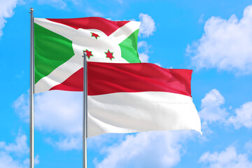 Indonesia and Burundi national flag waving in the windy deep blue sky. Diplomacy and international relations concept.