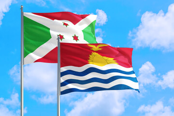 Kiribati and Burundi national flag waving in the windy deep blue sky. Diplomacy and international relations concept.
