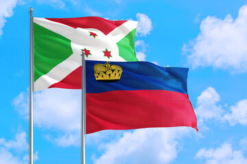 Liechtenstein and Burundi national flag waving in the windy deep blue sky. Diplomacy and international relations concept.