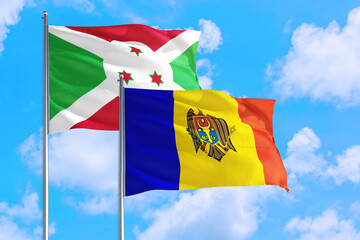 Moldova and Burundi national flag waving in the windy deep blue sky. Diplomacy and international relations concept.