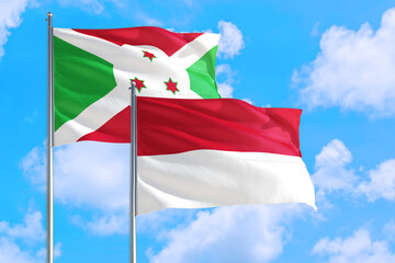 Monaco and Burundi national flag waving in the windy deep blue sky. Diplomacy and international relations concept.