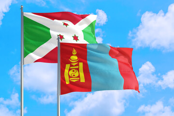Mongolia and Burundi national flag waving in the windy deep blue sky. Diplomacy and international relations concept.