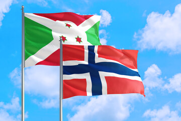 Norway and Burundi national flag waving in the windy deep blue sky. Diplomacy and international relations concept.