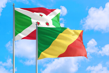 Republic Of The Congo and Burundi national flag waving in the windy deep blue sky. Diplomacy and international relations concept.