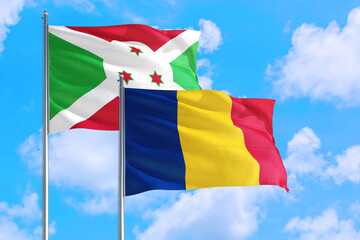 Romania and Burundi national flag waving in the windy deep blue sky. Diplomacy and international relations concept.