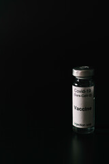 Covid 19 vaccine jar on a black background