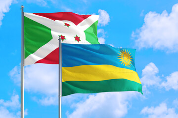 Rwanda and Burundi national flag waving in the windy deep blue sky. Diplomacy and international relations concept.