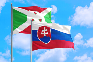 Slovakia and Burundi national flag waving in the windy deep blue sky. Diplomacy and international relations concept.