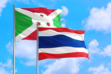 Thailand and Burundi national flag waving in the windy deep blue sky. Diplomacy and international relations concept.