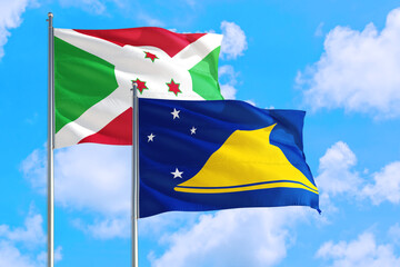 Tokelau and Burundi national flag waving in the windy deep blue sky. Diplomacy and international relations concept.