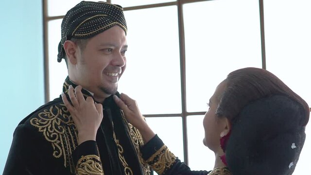happy men and women wearing javanese traditional clothes. beskap and kebaya for java wedding