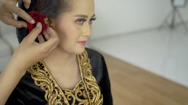 Close up woman have a makeup service by makeup artist in traditional java wedding clothes