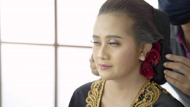 Close up woman have a makeup service by makeup artist in traditional java wedding clothes