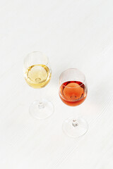 Rose and white wine in glass on light wooden table