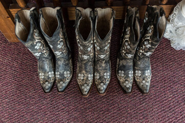 top view of multiple country western cowboy boots in a line