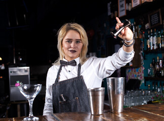 Girl bartender creates a cocktail in the porterhouse