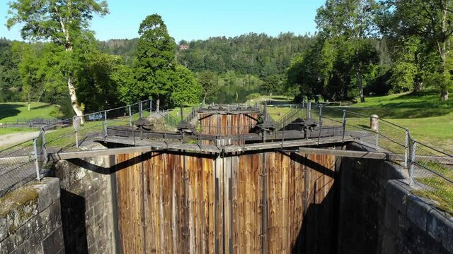 Aerial rising out of old lock chamber with large wooden gate in front