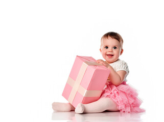 Cute baby girl sitting on the floor with a gift box and smiling