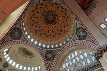 Obraz premium The interior of the mosque. The inner surface of domes and arches is painted in gold, silver, burgundy tones, decorated with ornaments. Along the perimeter of the window. Turkey