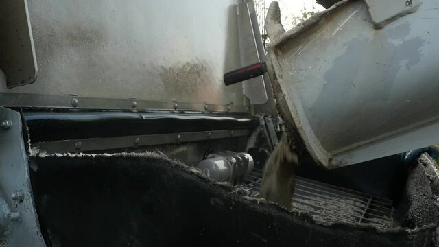 a concrete mixer dumps fresh concrete into a concrete pump