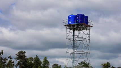 Blue platic water tank on the tower. Four outdoor storage tanks, metal construction for communities...