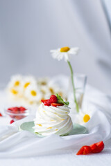 Meringue and whipped cream cake decorated with strawberries and mint